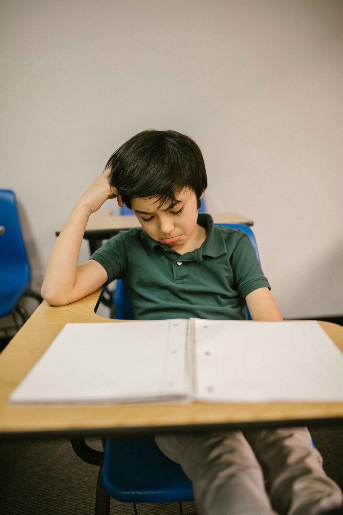 Niño frente a un cuaderno abierto en su pupitre
